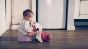 baby-toddler-on-pink-pot-with-roll-of-toilet-paper